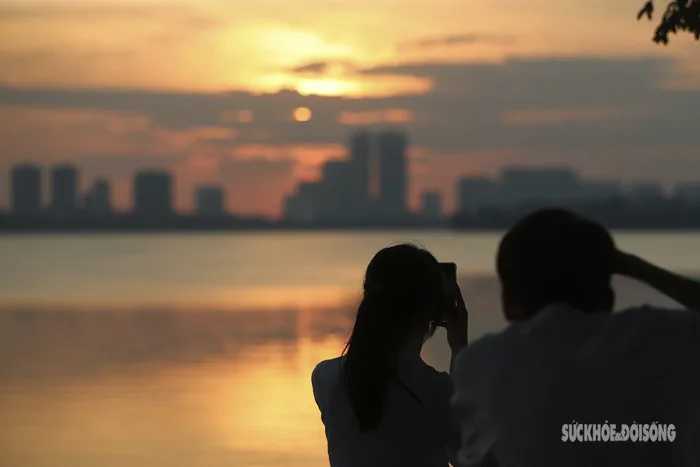 Du khách nước ngoài mê mẩn ngắm hoàng hôn ở Hồ Tây
